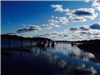 Boats docked at a lake under the blue sky and clouds 