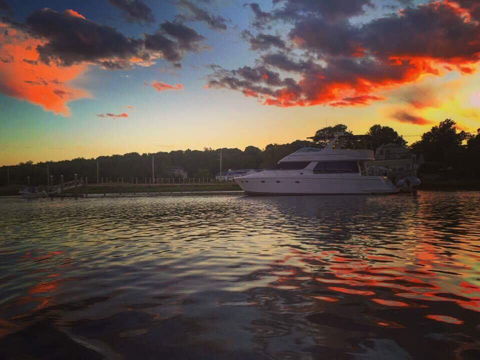 Red and gray clouds overlooking a boat on the lake during sunset