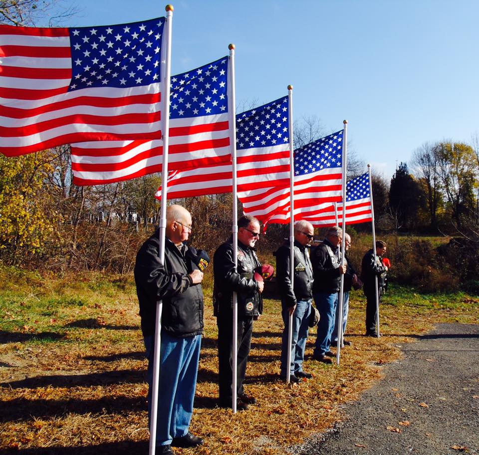Six veteran's standing with the American Flag